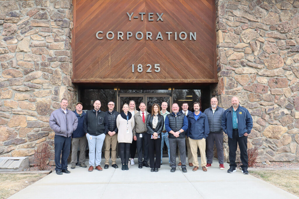 Y-TEX group standing in front of their building